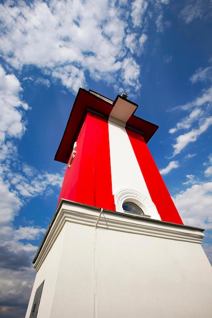 A red and white tower with a white stripe that says'the lighthouse '