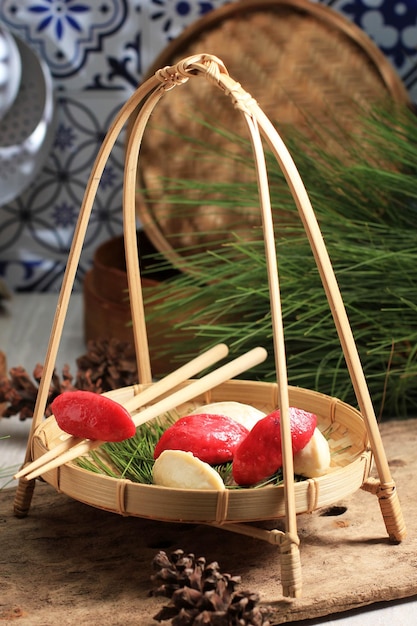 Red and White Traditional Chuseok Day Food, Korean Half Moon Shaped Rice Cake or Songpyeon. Made from Korean Rice Flour with Sesame Seed or Chopped Nuts, Honey, or Red Bean Paste, Served with Tea