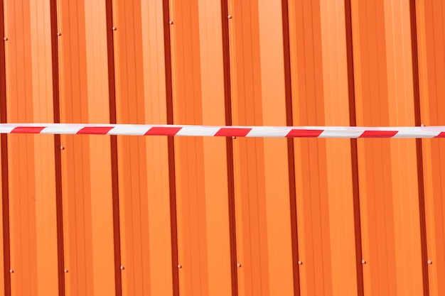 Photo red and white warning caution tape on an orange background danger unsafe area warning do not enter concept of no entry copy space