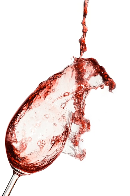 Red wine being poured into a glass on a white background