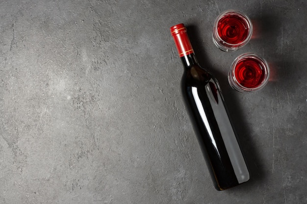 Red wine in a bottle Black concrete background Flat lay Copy space