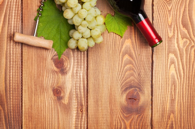 Red wine bottle and bunch of white grapes