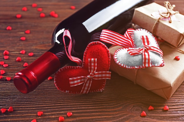 Photo red wine bottle and gift box on wooden background