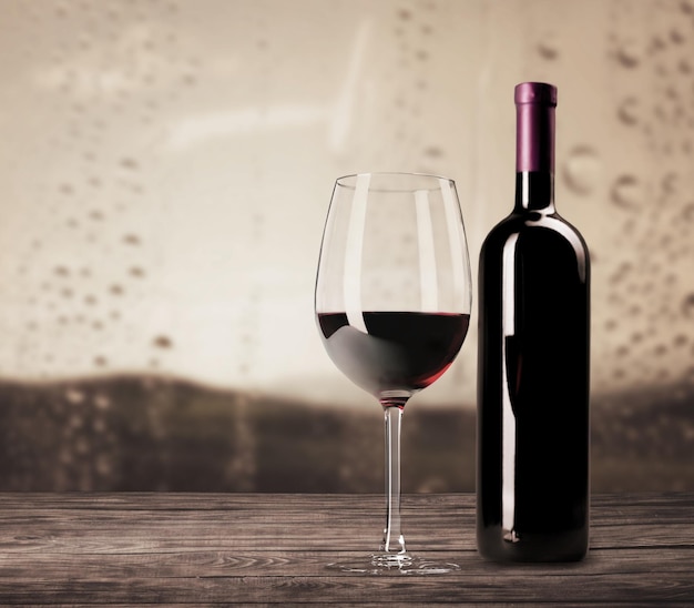 Red wine in bottle and glass on wooden table