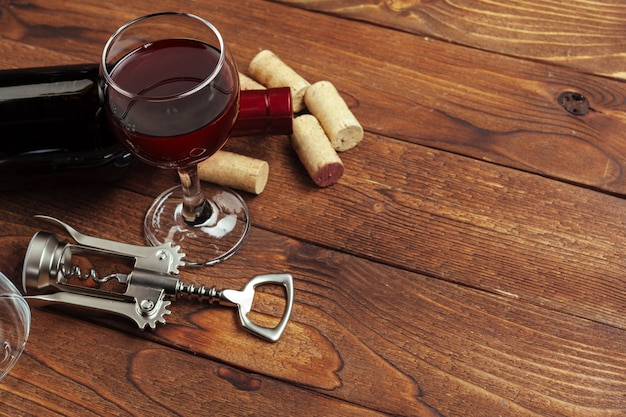 Red wine bottle, wine glass and corkscrew