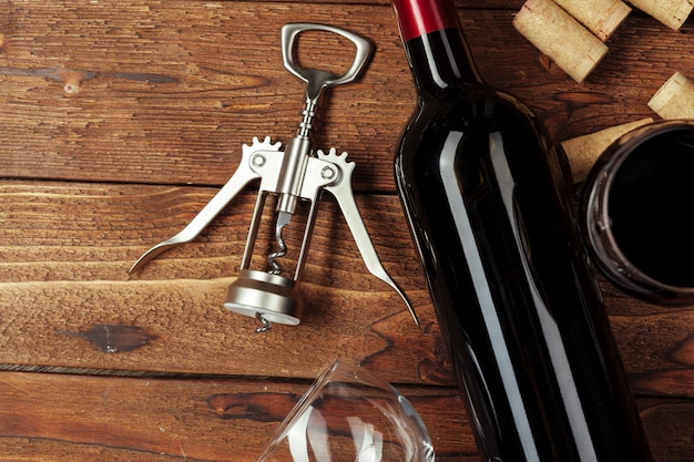 Red wine bottle, wine glass and corkscrew