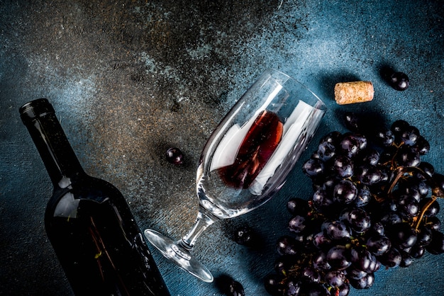 Red wine bottle with glass and grapes