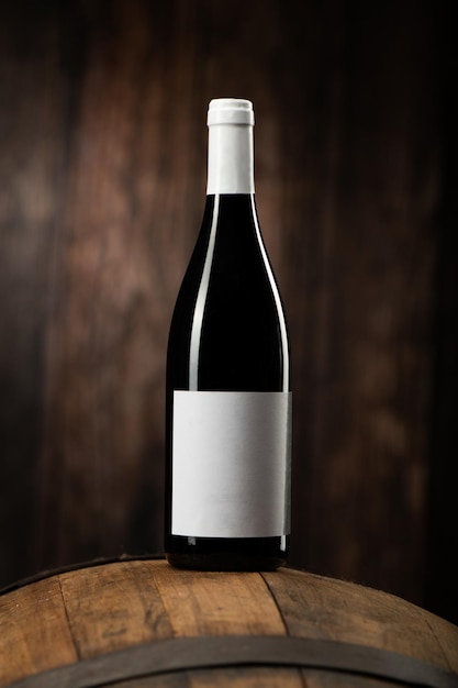 Бутылка красного вина на деревянной бочке с деревянным фоном