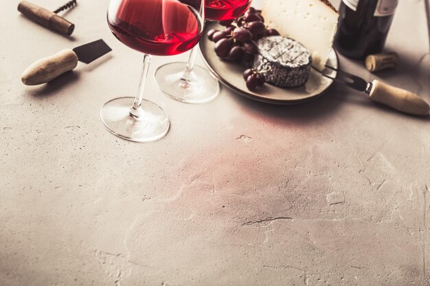 Red wine and cheese on concrete background