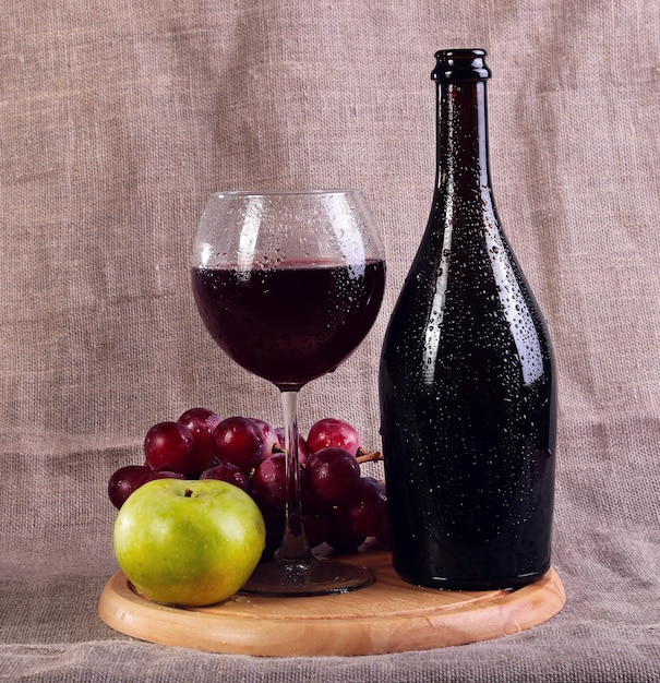 Red wine, cheeses and grapes in a still life setup.
