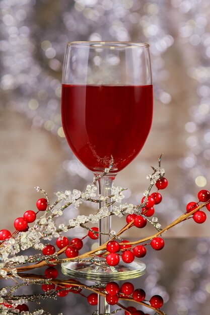 Red wine and Christmas ornaments on wooden table on wooden background