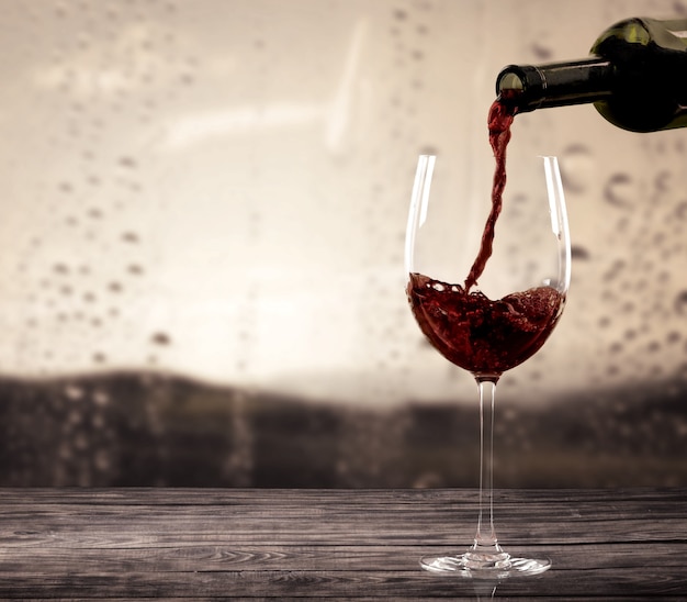 Red wine and glass on background