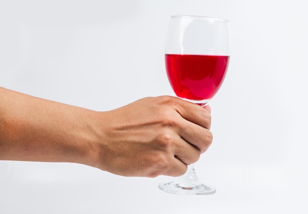 Red wine glass in hand on white background