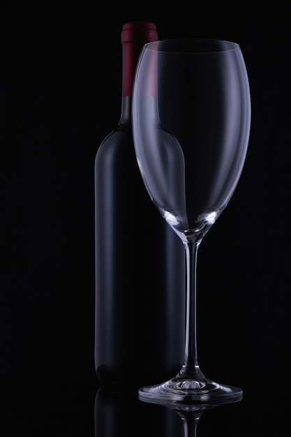 Red wine glass and a wine bottle on dark background