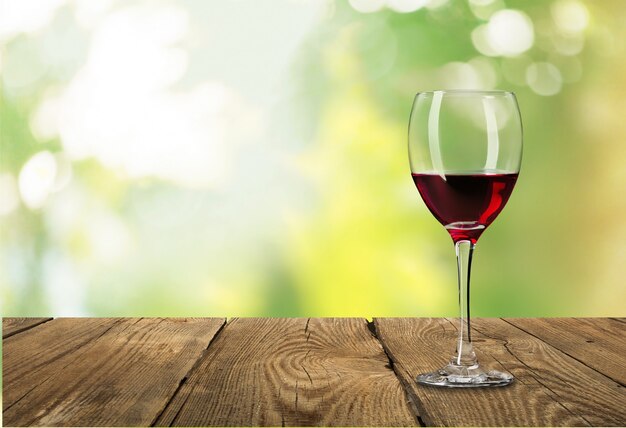 Red wine glass on wooden desk