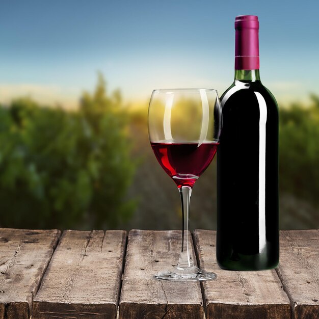 Red wine and glass on wooden table