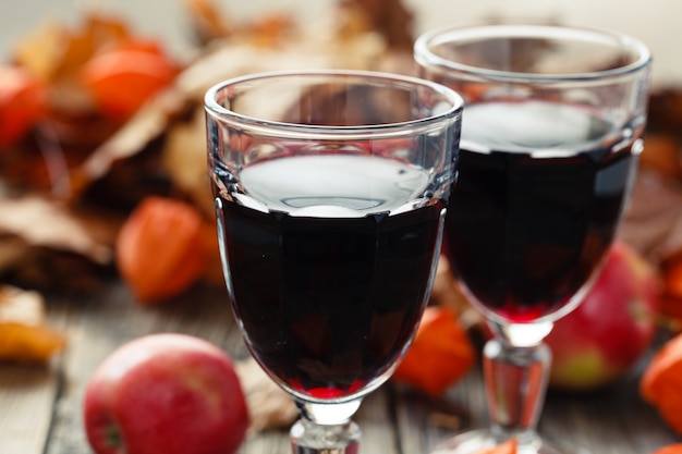 Red wine in glasses on table in fall leaf