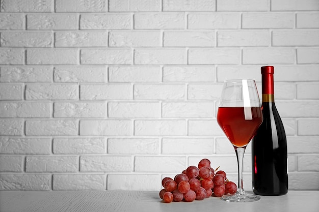 Red wine and grape on brick wall background