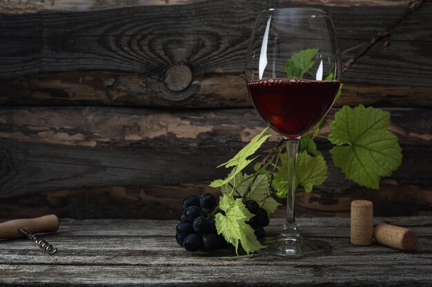 Red wine and grapes. Wine and grapes in a vintage setting with corks on a wooden table.