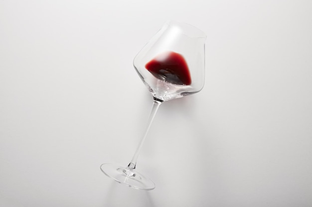赤ワインはライトグレーで隔離された脚付きグラスの中にあります