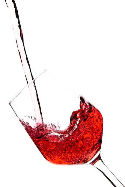 Red wine is pouring into a glass goblet on a white background. Alcoholic drinks. High quality photo