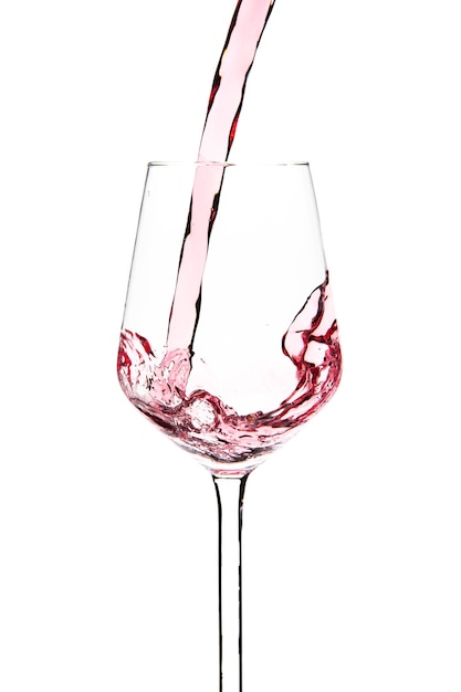 Red wine is pouring into a glass goblet on a white background. Alcoholic drinks. High quality photo