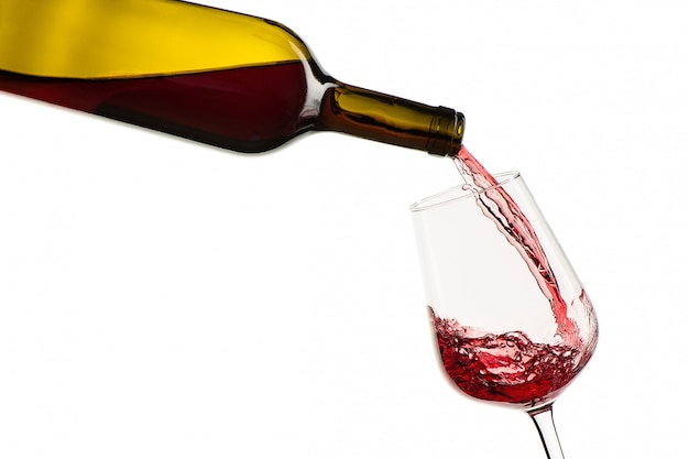 Photo red wine pouring from bottle into glass on a white background