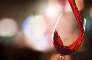 Фото Красное вино льется в стакан на фоне