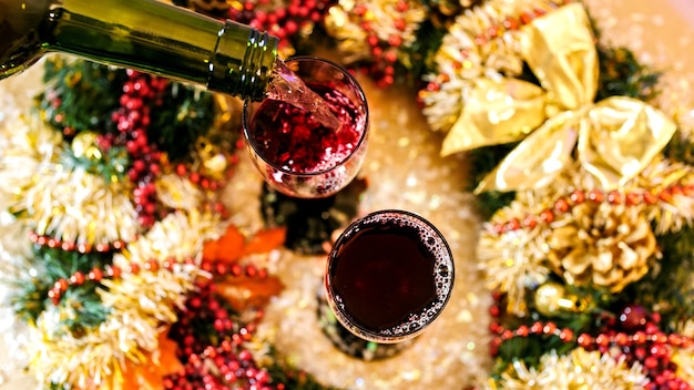 Red wine pouring into a glass top view