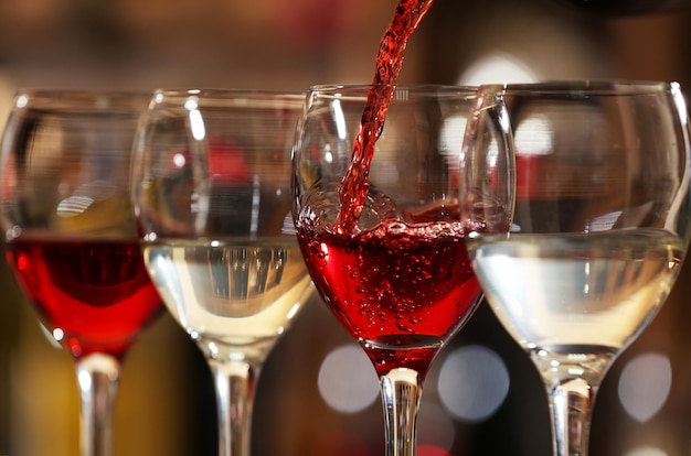 Red wine pouring into wine glass closeup