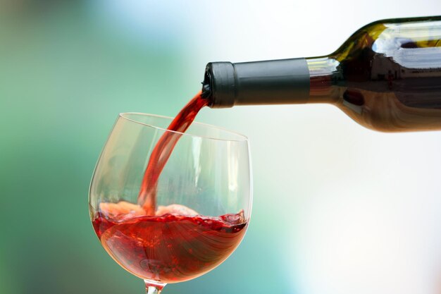 ワイングラスのクローズアップに注ぐ赤ワイン