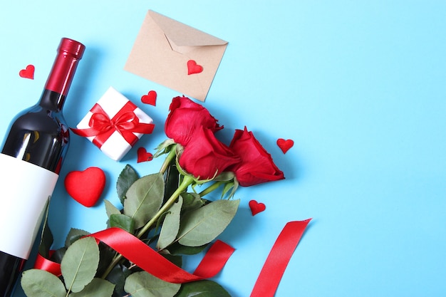 Red wine and roses on the table valentines day background