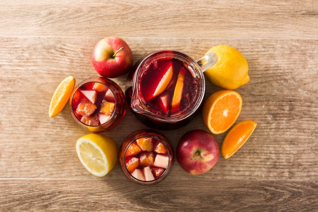 Red wine sangria in glass on wooden table, top view