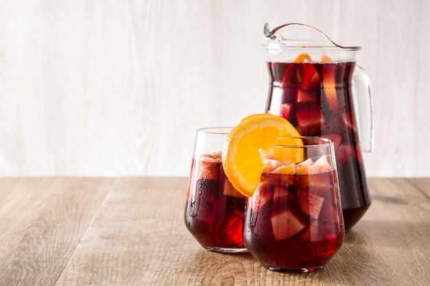 Red wine sangria in glass on wooden table