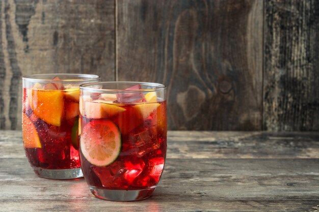 Red wine sangria in glass on wooden table 