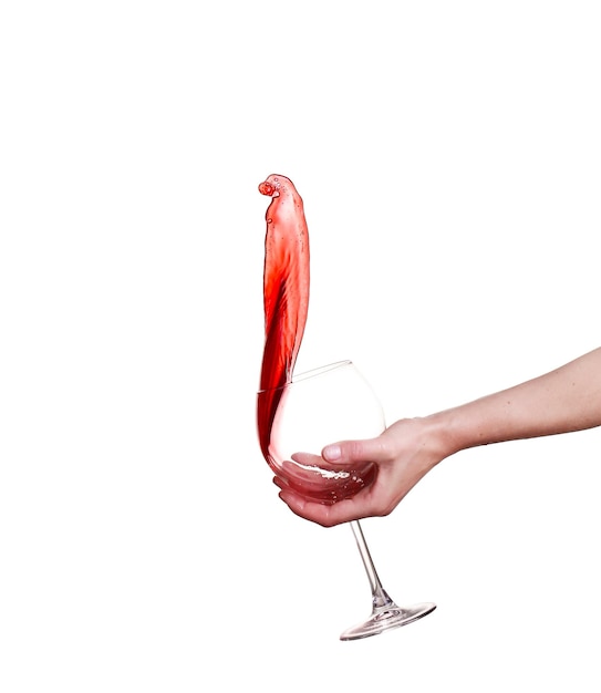 白い背景で隔離のガラスからはねかける赤ワイン