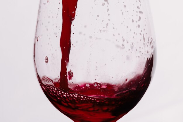 Photo red wine splashing in a glass. glass of wine isolated on white background.