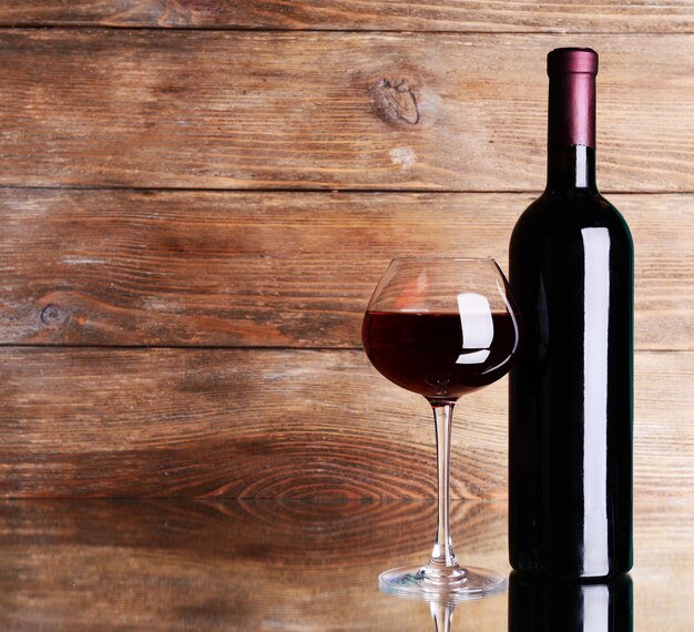 Red wine on table on wooden background