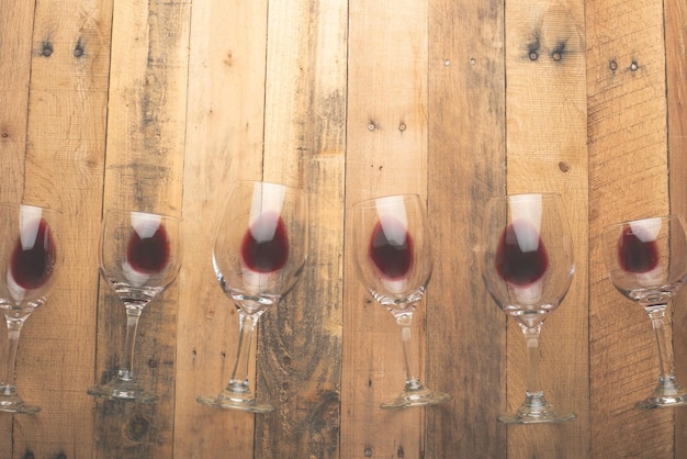 Red wine in transparent wine glasses on a wooden background Bojole nouveau wine bar winery winemaking wine tasting concept Flat lay