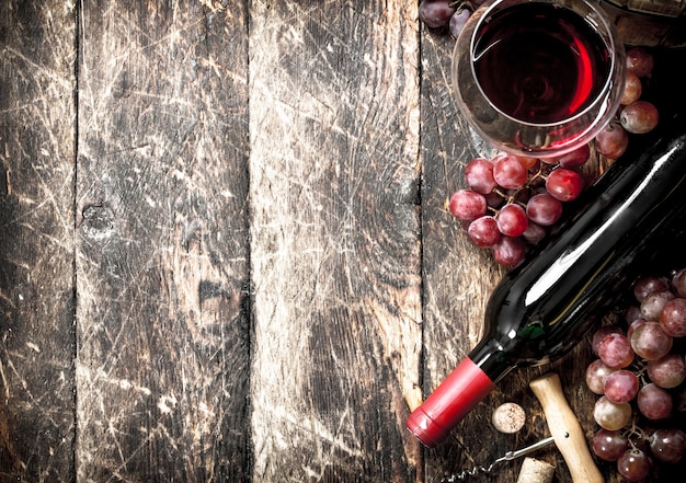 Красное вино в бокалах с виноградом.
