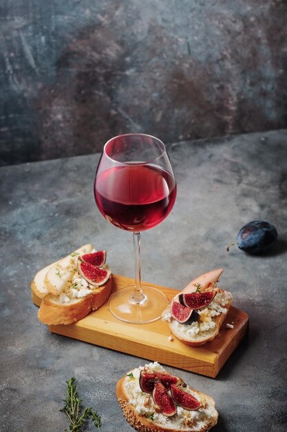 Red wine with snacks bruschetta with pears cottage cheese figs thyme nuts and honey camembert cheese