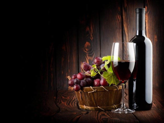 木製の背景にワイングラスと赤ワイン