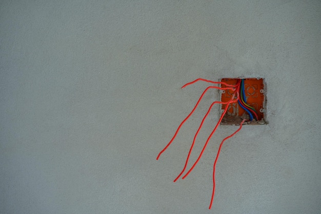 Фото Красные провода в отверстии в стене