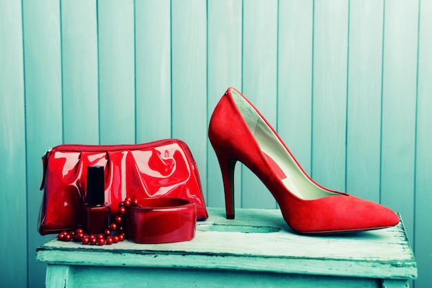 Красные женские туфли и косметолог на деревянном фоне