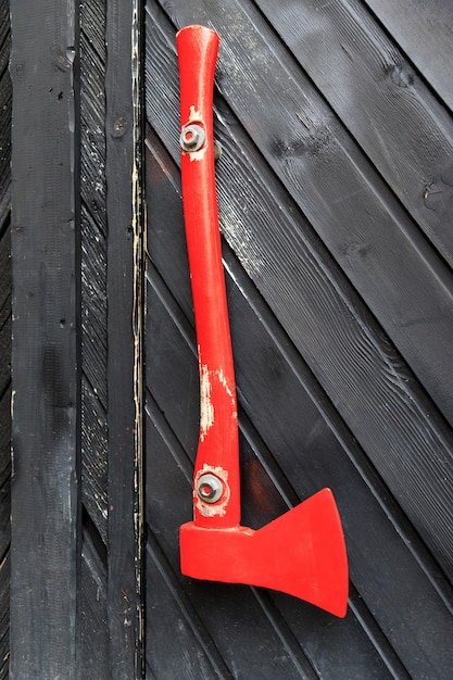 Red wood chopper hanging on a wooden gate