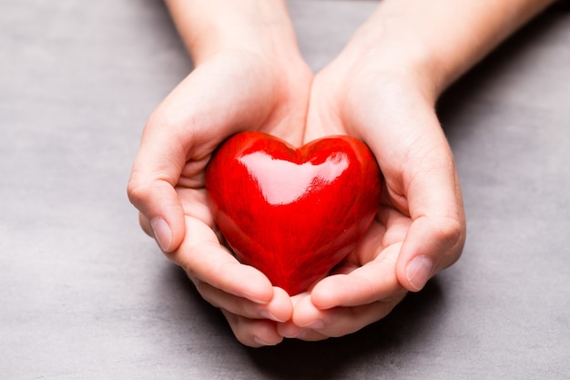 Red wood heart in child hands.