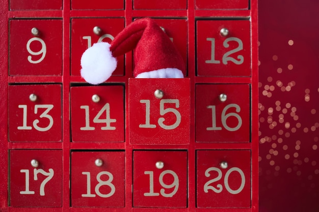 クリスマスの驚きと赤い木製のアドベントカレンダー。