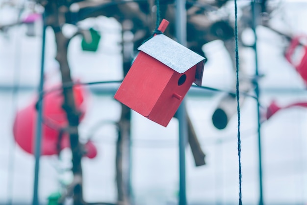 Red wooden birdhouse decoration hanging on the thread