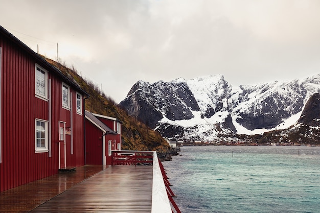 Red wooden cabins by the lake in the winter