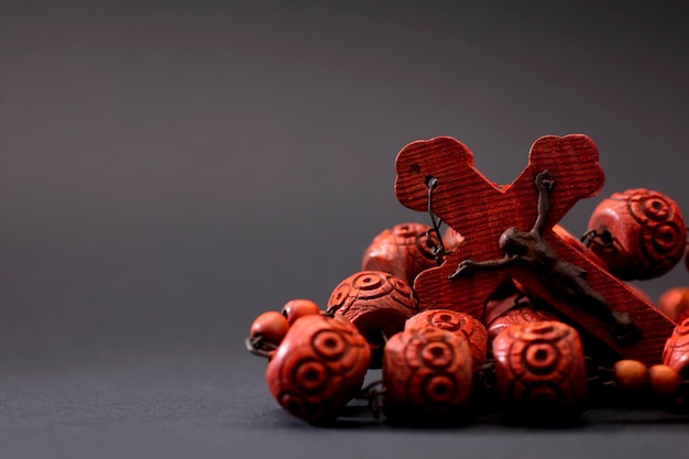 red wooden catholic rosary on a gray background, space for text